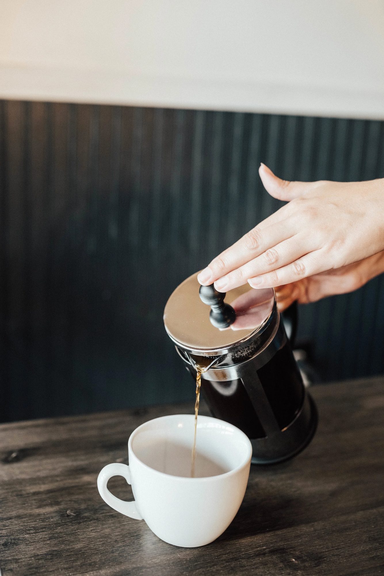Pressing a French press of fresh coffee